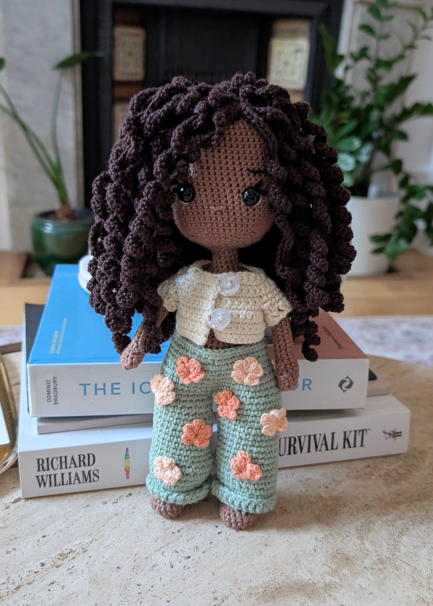 Crocheted doll with floral pants.
